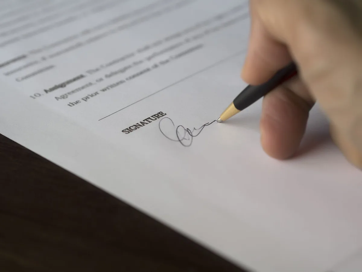 Signature d'un contrat professionnel avec stylo sur bureau