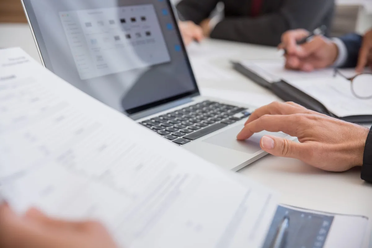 Ordinateur portable ouvert sur un bureau avec des documents numériques sécurisés dans le cloud