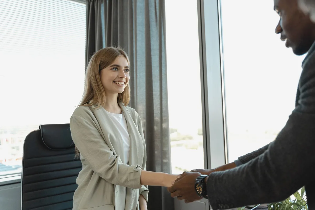 Candidat et recruteur qui signent une promesse d'embauche dans un bureau