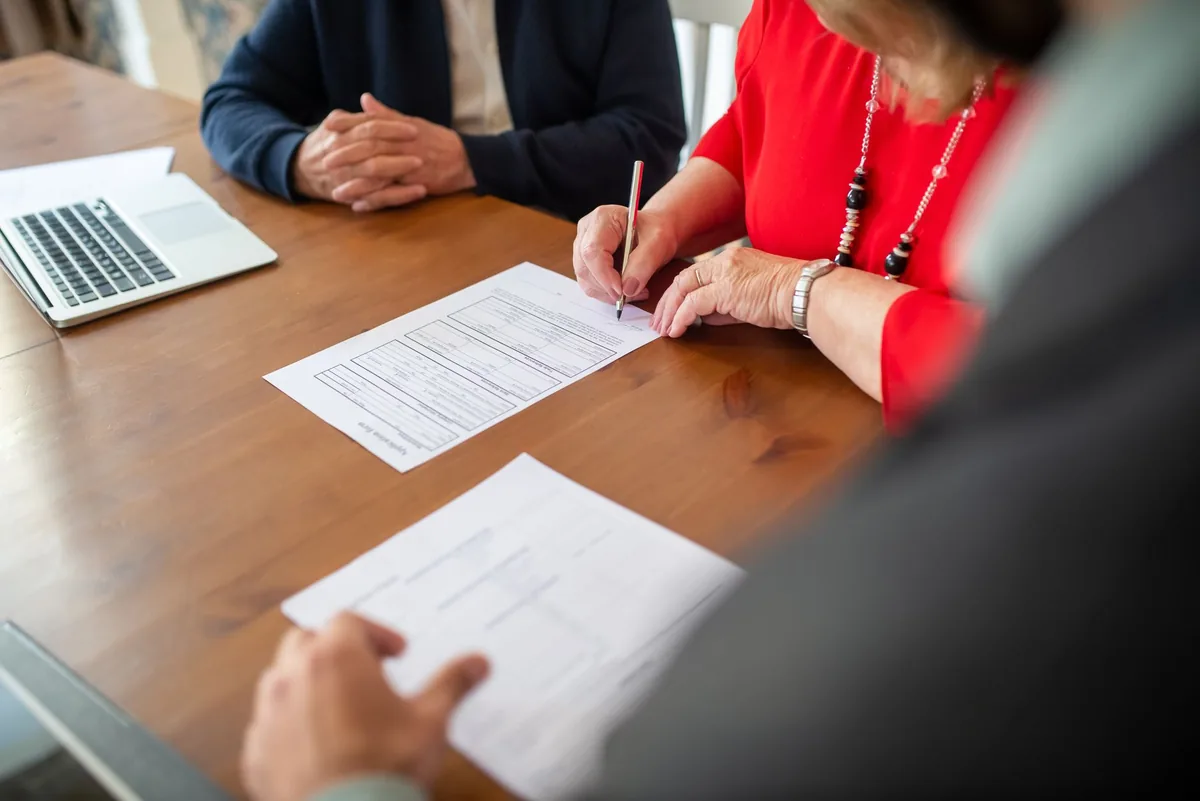 Entrepreneur signant des documents contractuels sur son bureau
